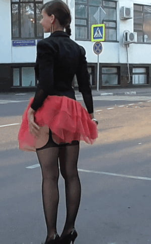 Брюнетка показывает попу задрав красную юбку