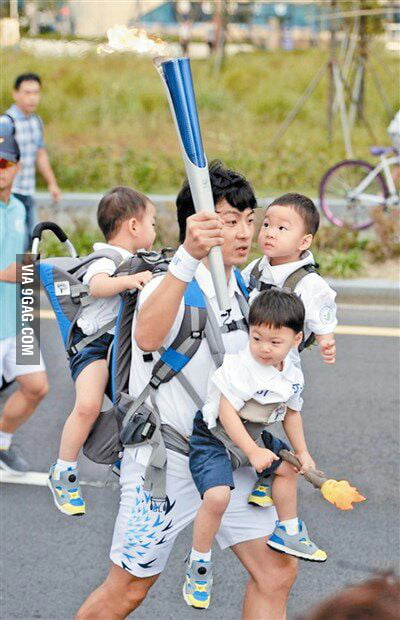 this-guy-runs-300m-torch-relay-while-carrying-his-triplets-9gag