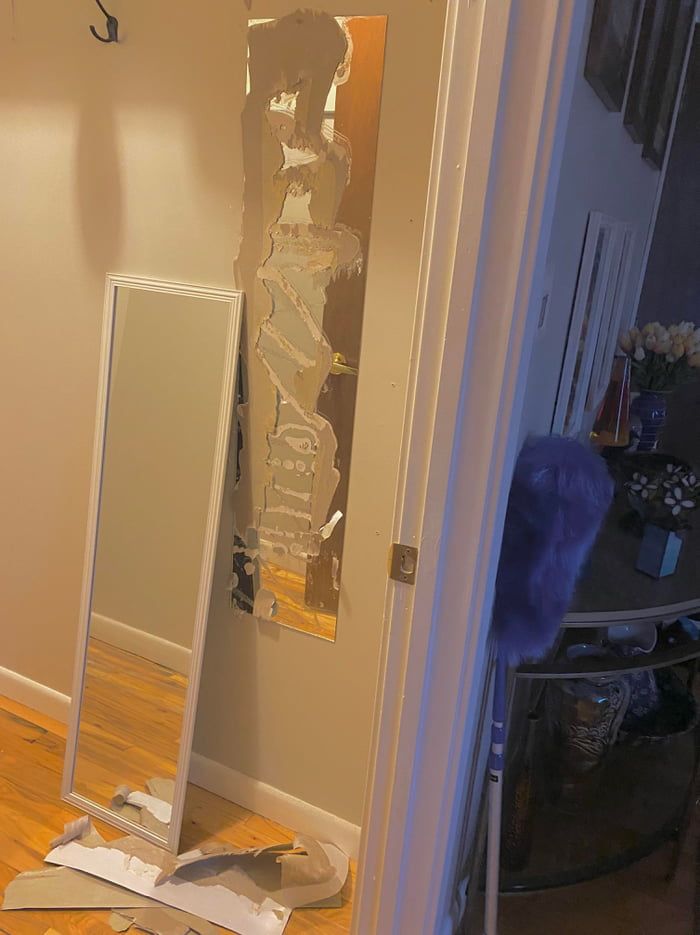 Removing a cheap mirror glued to the wall, only to find an even cheaper