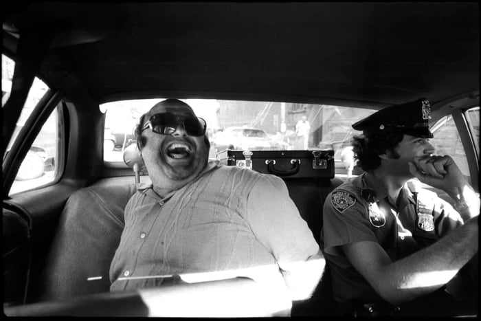Criminal laughing sitting next to cop. New York 1970's - 9GAG