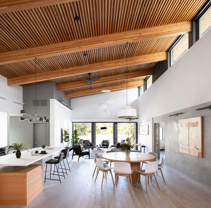 Double-height living and dining area with timber ceilings and automated ...