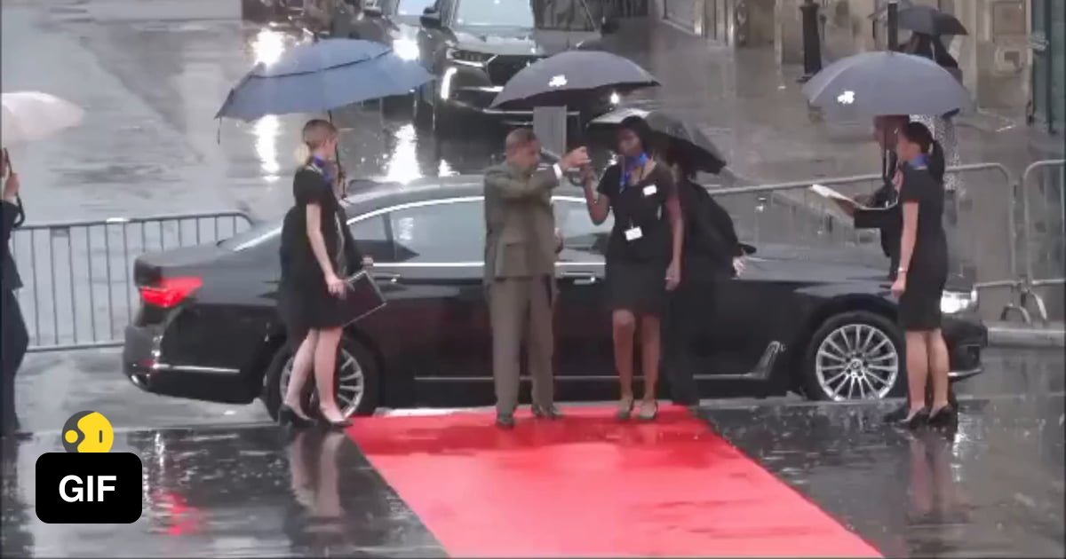 Pakistan S Prime Minister Shehbaz Sharif Takes An Umbrella From A