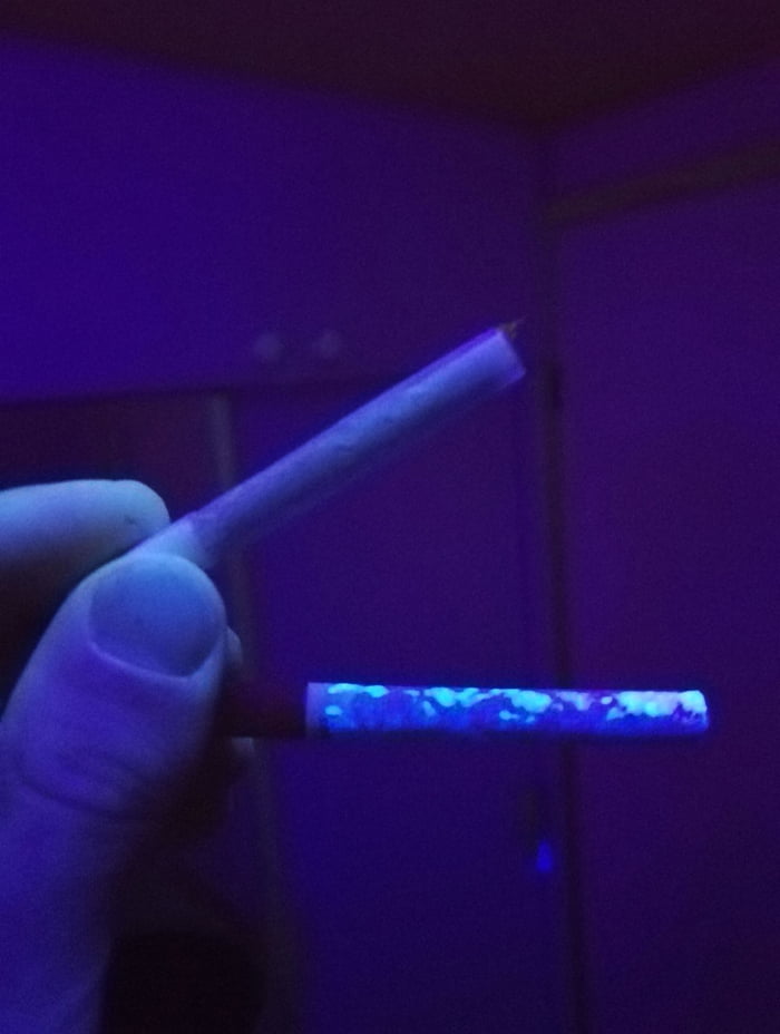 Rolled and factory cigarette under UV light