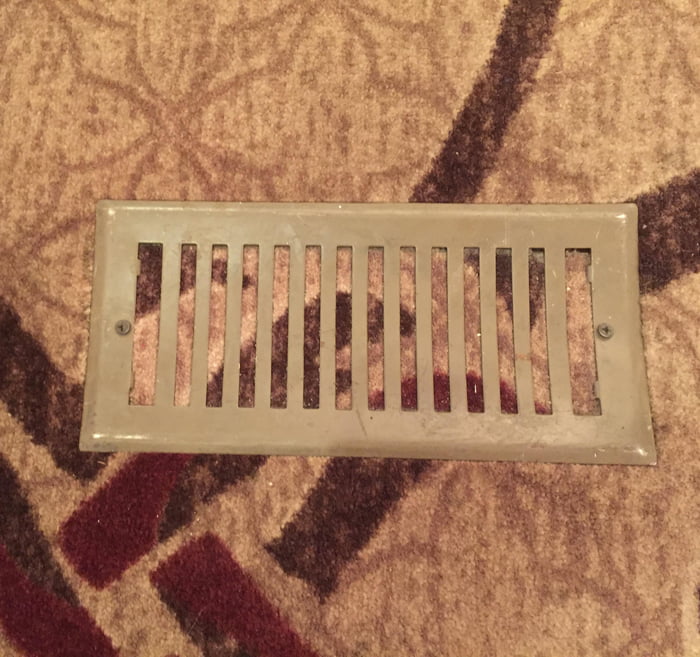 Carpet installed over an air vent, vent cover installed over the carpet