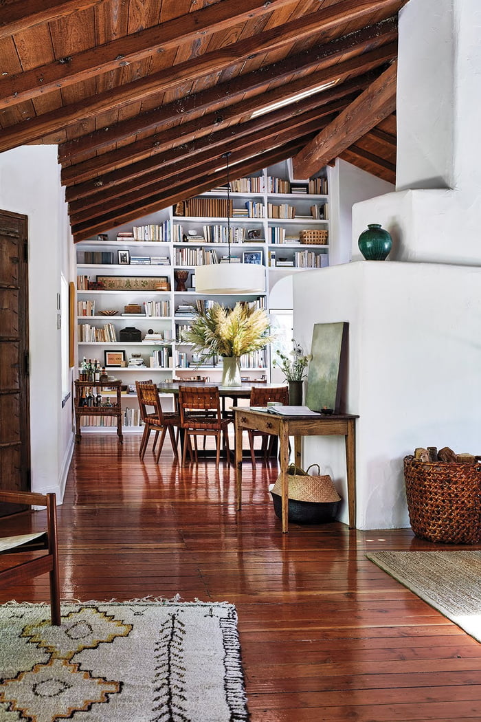 Builtin bookcase wall under a vaulted ceiling with beams in a mid