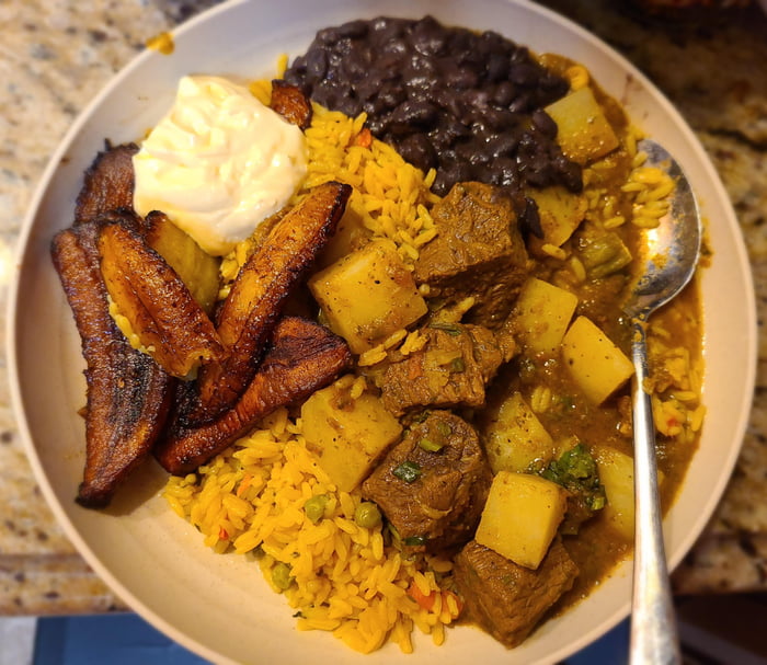 Carne guisada, platanos, crema, rice, and beans from Pupuseria Mana in