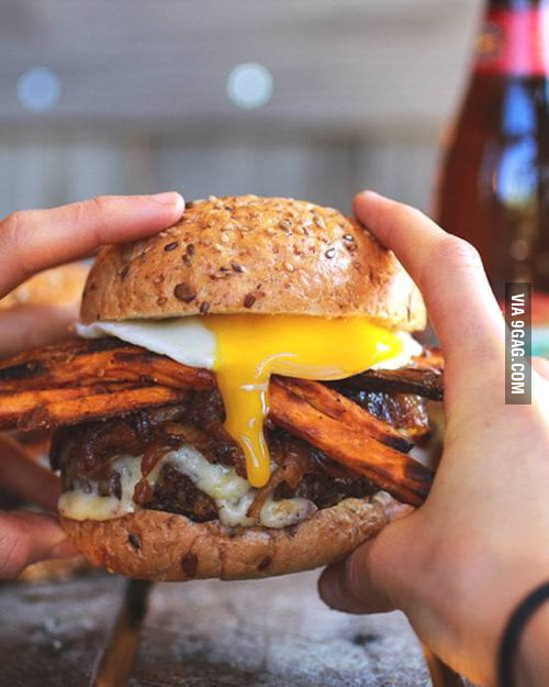 A burger with an egg, fries, bacon and cheese. I need this in my life ...