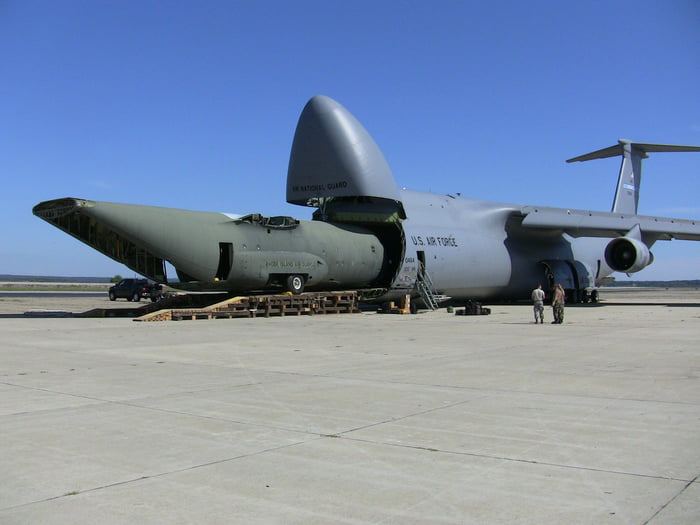 Of a plane (C-130 Hercules fuselage)... being transported as cargo by ...