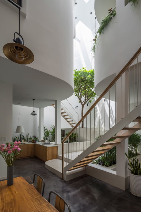Open Plan Living Spaces Full Of Greenery Centered Around A Triple