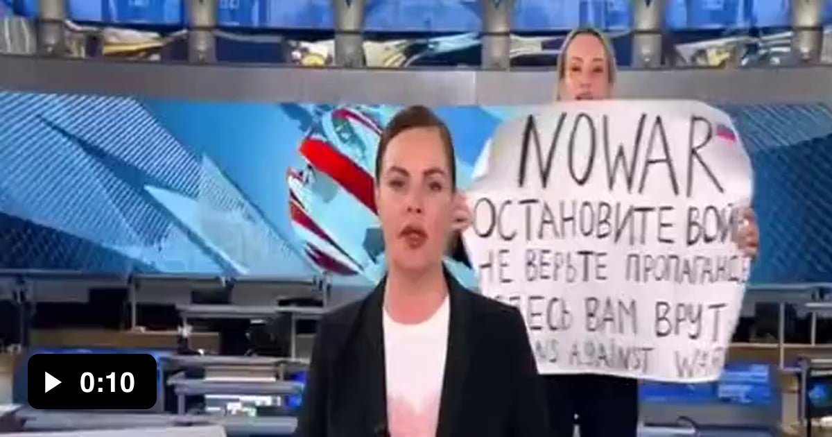 1 канал прямой 1 эфир 03. Женщина с плакатом в эфире. Плакат в эфире новостей. Плакат в прямом эфире первого канала.