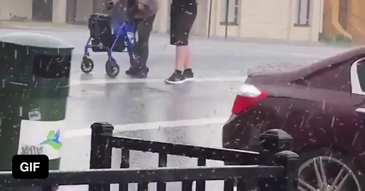 14-year-old-boy-with-umbrella-helps-an-elder-cross-the-street-during-a